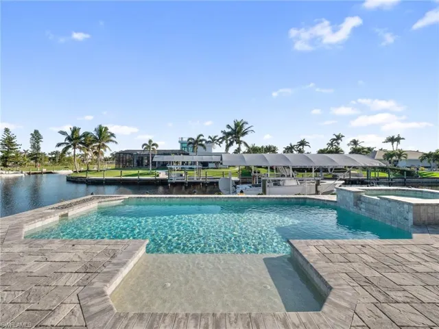 View of pool featuring a water view and a pool with connected hot tub