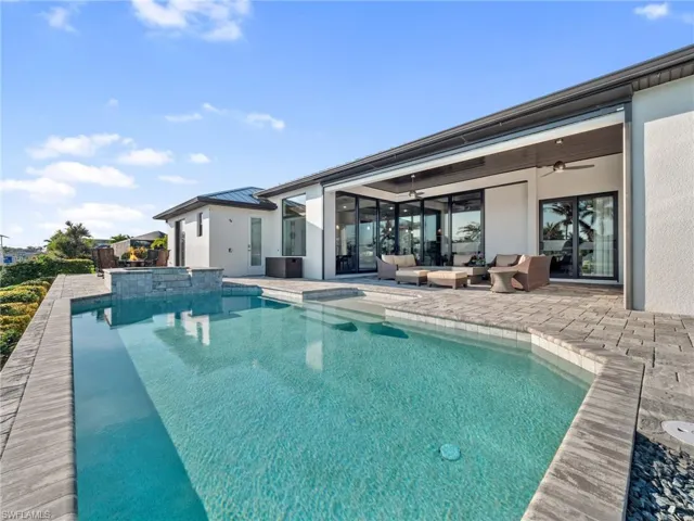 View of pool with a pool with connected hot tub, an outdoor living space, a patio area, and a ceiling fan