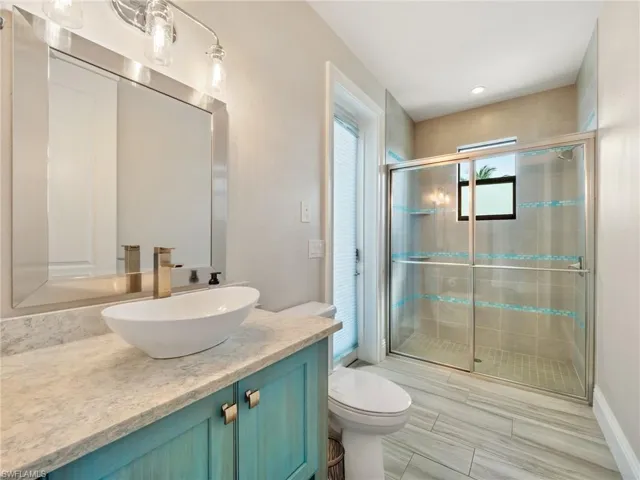 Bathroom with toilet, a shower stall, and vanity