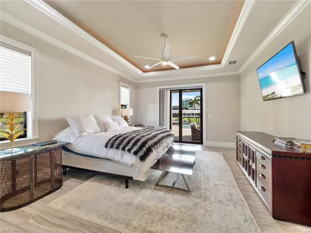 Bedroom with light wood finished floors, visible vents, ornamental molding, access to outside, and a tray ceiling