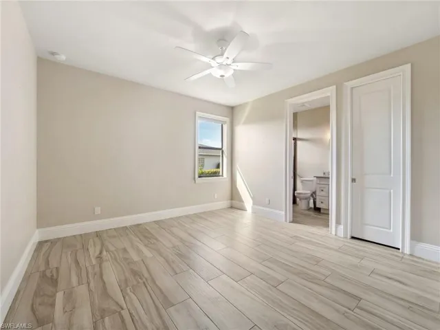Unfurnished bedroom with light wood-style floors, baseboards, and a ceiling fan