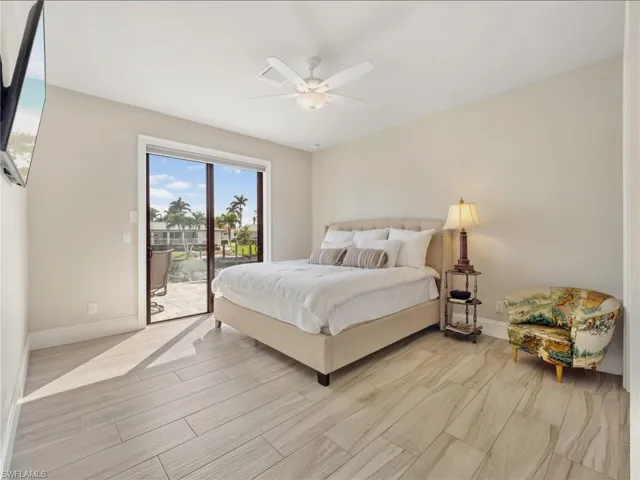 Bedroom with access to exterior, ceiling fan, light wood finished floors, and baseboards