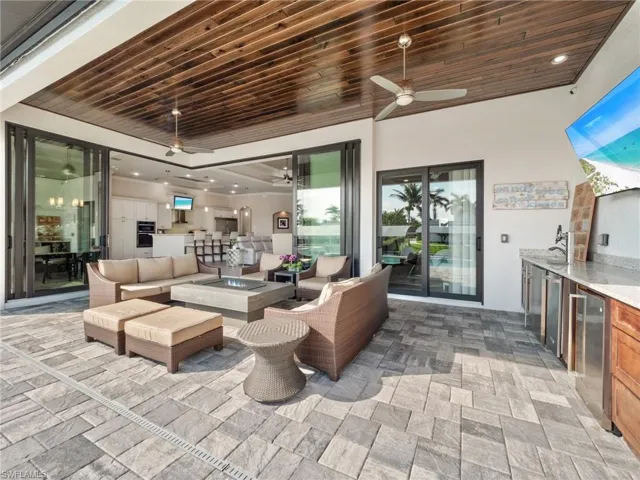 View of patio / terrace with an outdoor living space with a fire pit, ceiling fan, and area for grilling