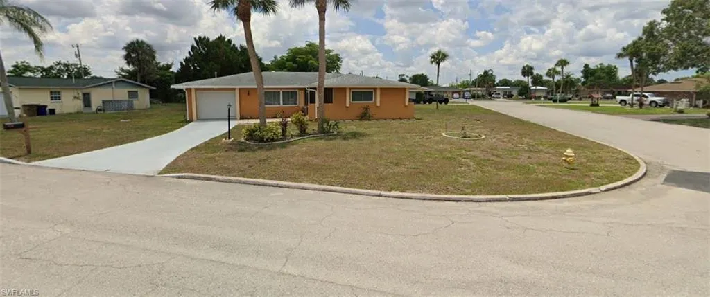 Ranch-style house featuring driveway, a front lawn, and a garage