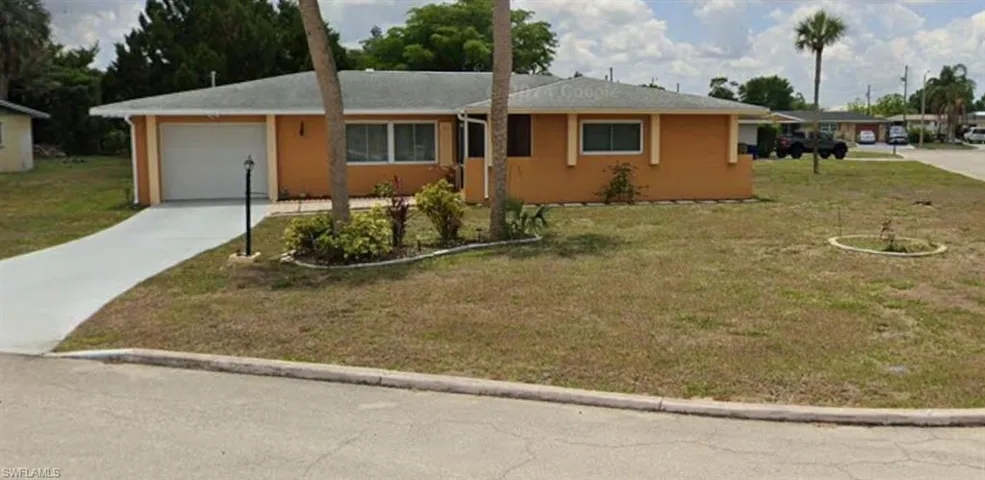 Ranch-style home with an attached garage, concrete driveway, a front lawn, and stucco siding
