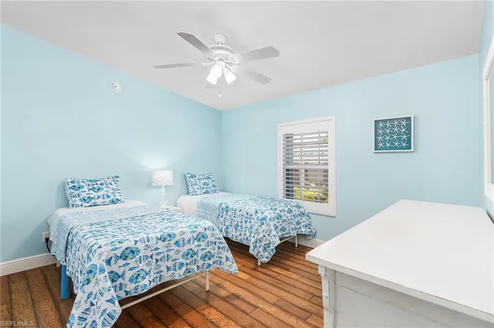 Bedroom featuring baseboards, ceiling fan, and wood finished floors