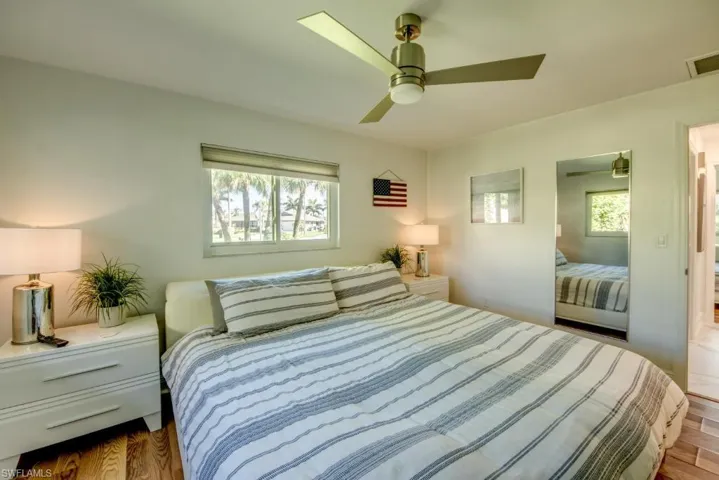 Bedroom featuring light wood-style floors, a ceiling fan, and multiple windows