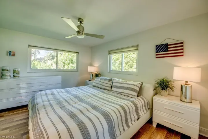 Bedroom with dark wood-type flooring and a ceiling fan