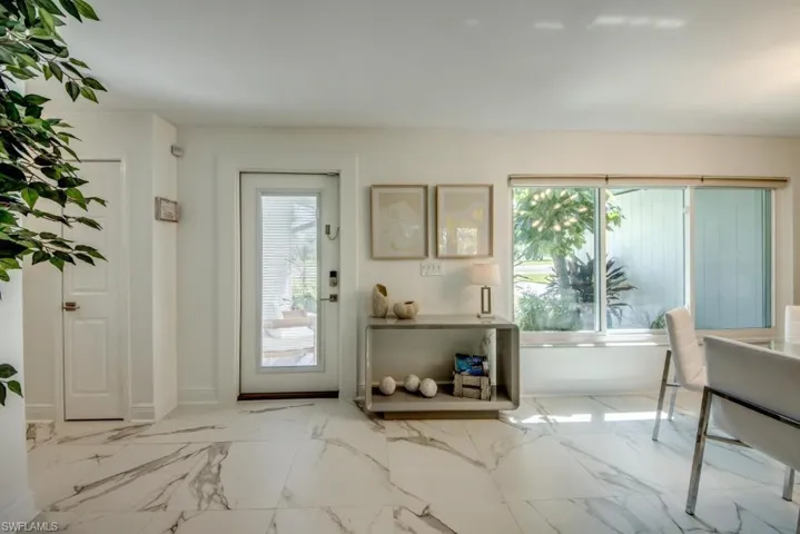 Doorway with marble finish flooring and baseboards