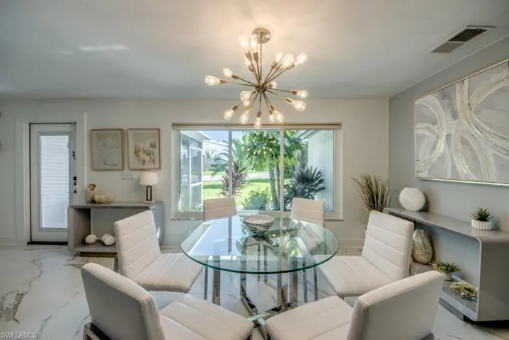 Dining space with marble look tiles and a chandelier