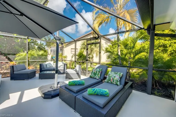 View of patio with a sunroom, an outdoor lounge area, and glass enclosure
