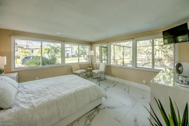 Bedroom featuring baseboards and light marble finish floors