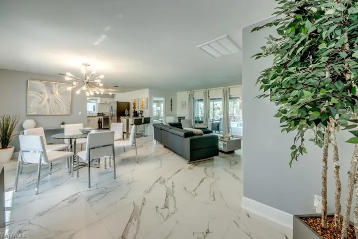 Living area featuring a chandelier and light marble finish floors