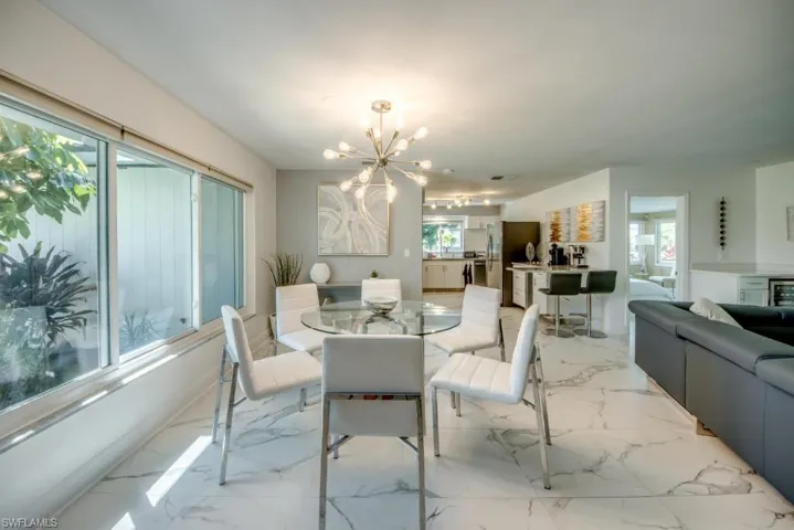 Dining room featuring a chandelier, wine cooler, and light marble finish flooring