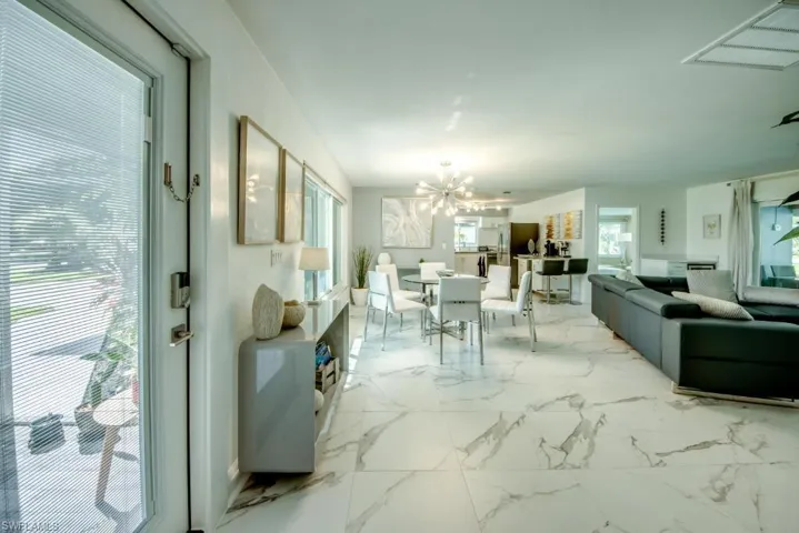 Dining area featuring hanging lights and light marble finish flooring