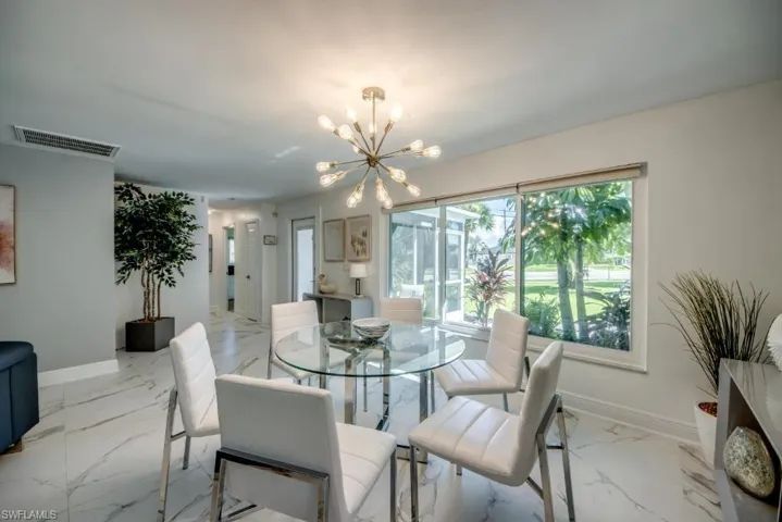 Dining space featuring baseboards and a chandelier