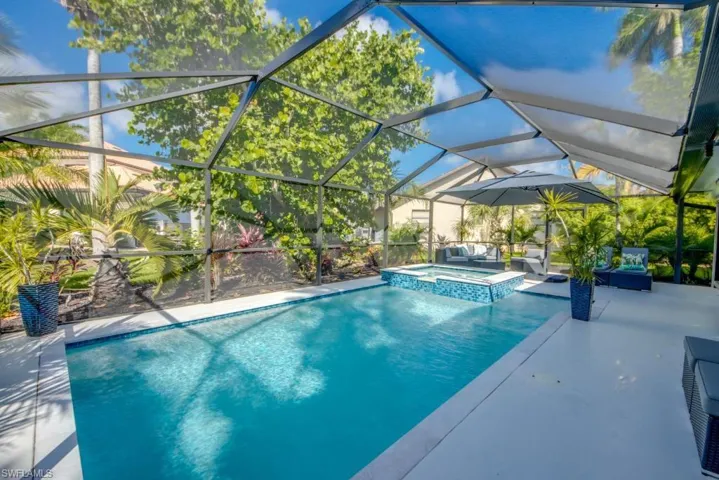 Combined pool / hot tub featuring a sunroom, a lanai, and a patio area