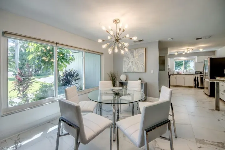 Dining area with light marble finish flooring and hanging lights