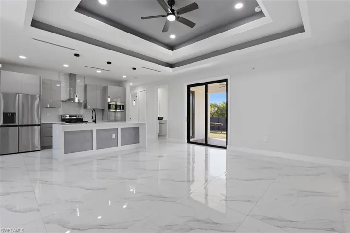 Unfurnished living room featuring recessed lighting, ceiling fan, and light marble finish floors
