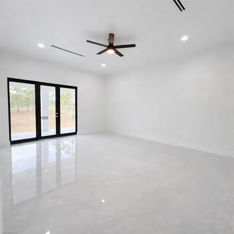 Unfurnished room with a ceiling fan, recessed lighting, and french doors