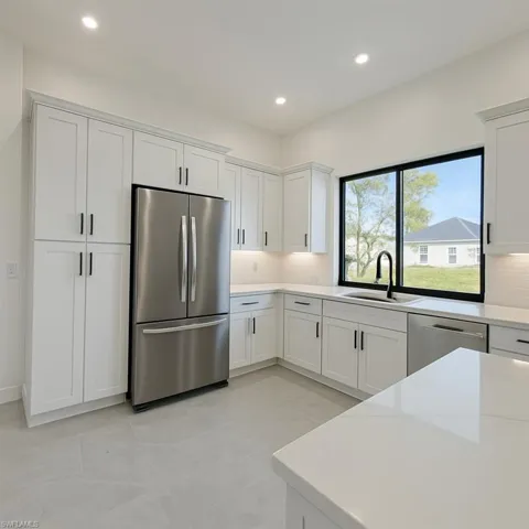 Kitchen with stainless steel appliances, white cabinets, tasteful backsplash, light stone counters, and recessed lighting