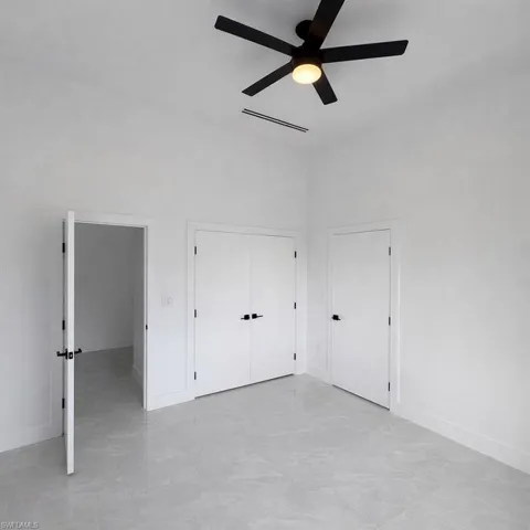 Unfurnished bedroom featuring a closet, a ceiling fan, and a high ceiling