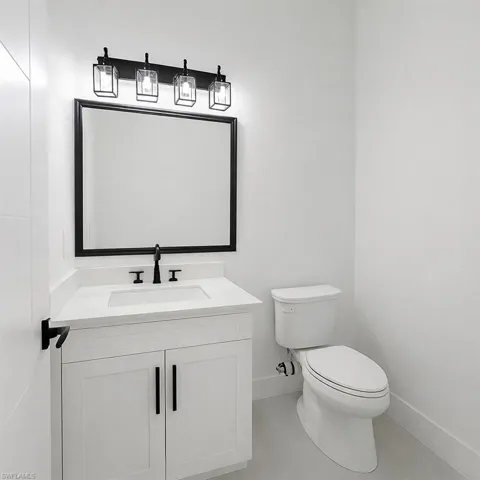 Half bathroom featuring vanity and toilet