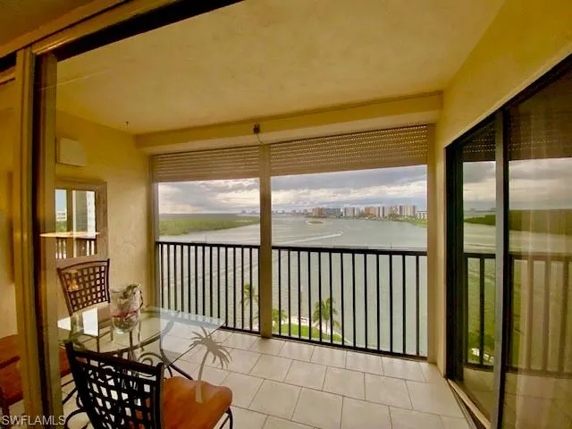 Sunroom with a water view and a view of city