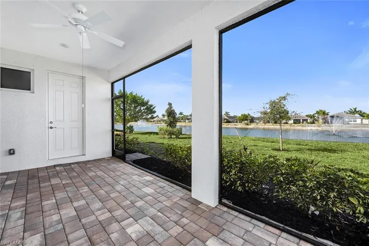 Unfurnished sunroom with ceiling fan and a water view
