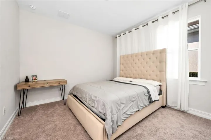Bedroom with baseboards and light carpet