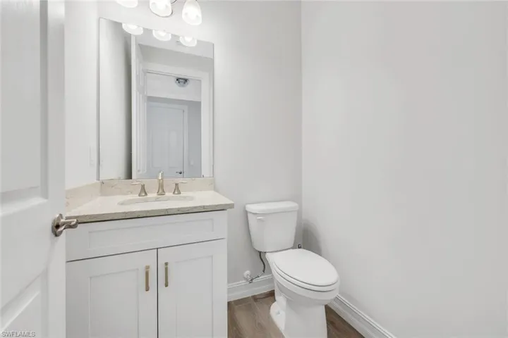 Half bath featuring vanity and wood finished floors