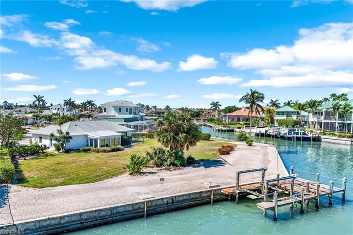View of dock with a water view, a yard, and a residential view