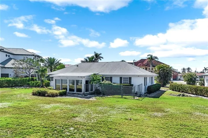 Back of house with a lawn, fence, and a sunroom