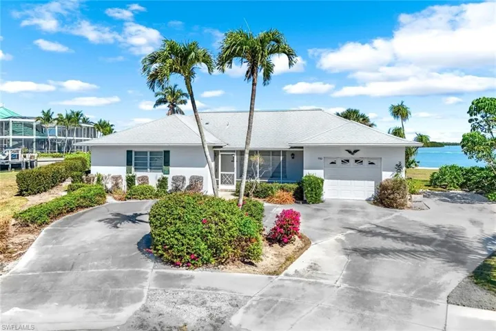 Ranch-style house with a water view, an attached garage, concrete driveway, and stucco siding
