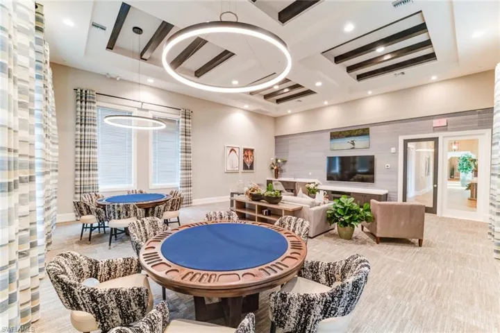 Recreation room with a raised ceiling, baseboards, beam ceiling, and coffered ceiling