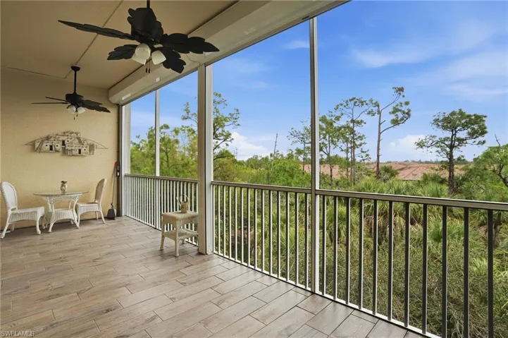 Unfurnished sunroom with a balcony and ceiling fan