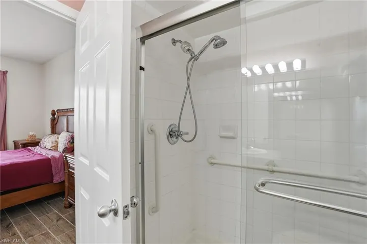 Full bath featuring ensuite bath, a shower stall, and wood tiled floors