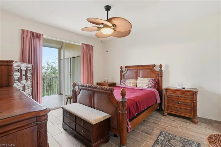 Bedroom featuring access to exterior, wood tiled floors, and a ceiling fan