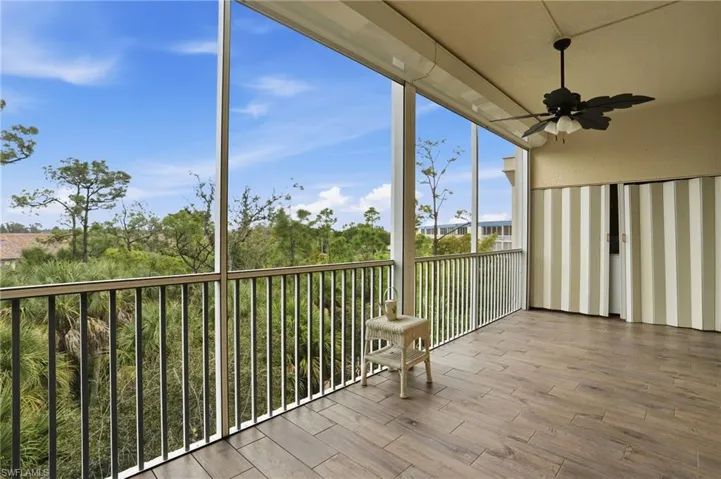 Unfurnished sunroom featuring a balcony and a ceiling fan