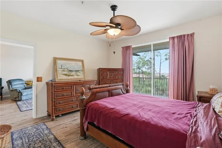 Bedroom with access to exterior, wood finish floors, and ceiling fan
