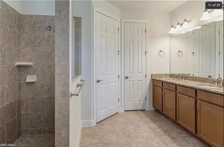 Luxurious primary bath with dual vanities, a walk-in shower, and elegant tile finishes.