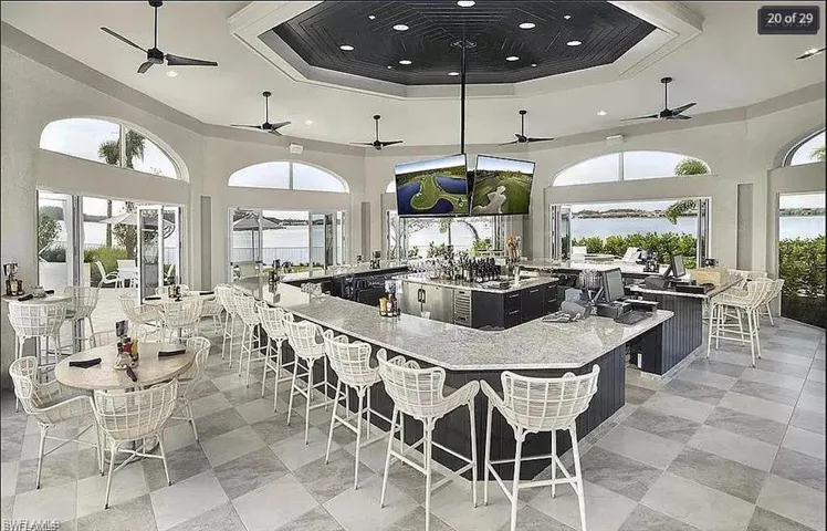 Upscale clubhouse kitchen and bar area with contemporary design and seating.