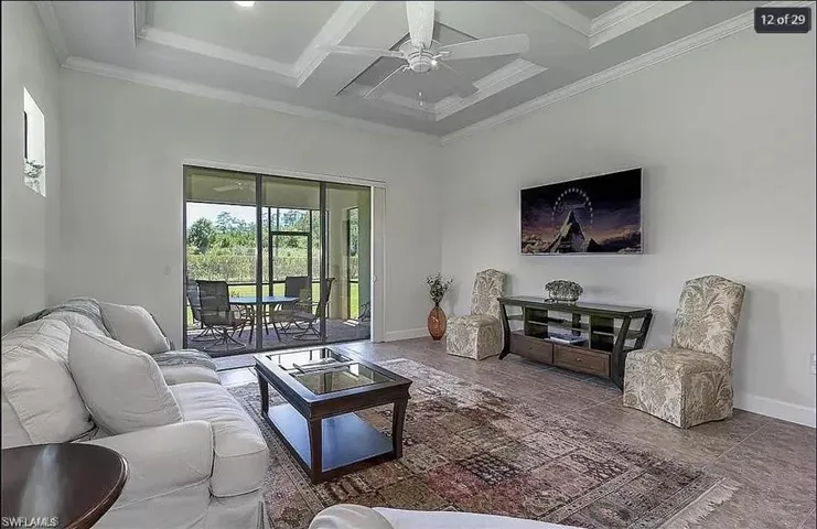 Open-concept living room with coffered ceilings and seamless indoor-outdoor flow.
