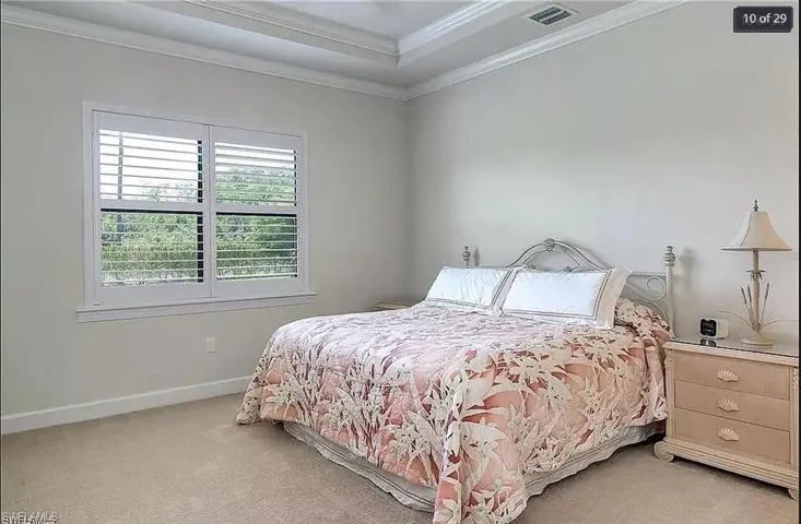 Spacious primary suite with a tray ceiling, large windows, and a relaxing atmosphere.