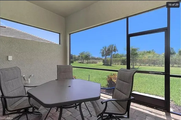Relaxing sunroom with screened lanai and serene views of lush greenery.