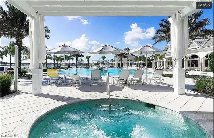 Expansive pool deck with shaded seating and tropical landscaping.