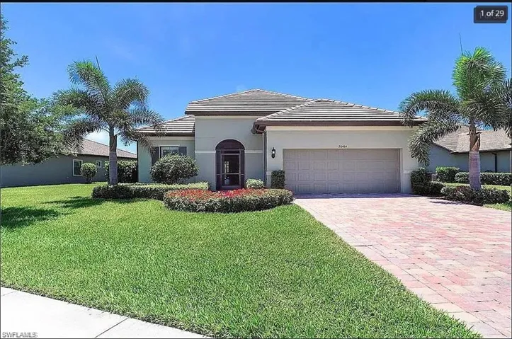 Beautifully maintained home with lush landscaping, a paved driveway, and charming curb appeal.