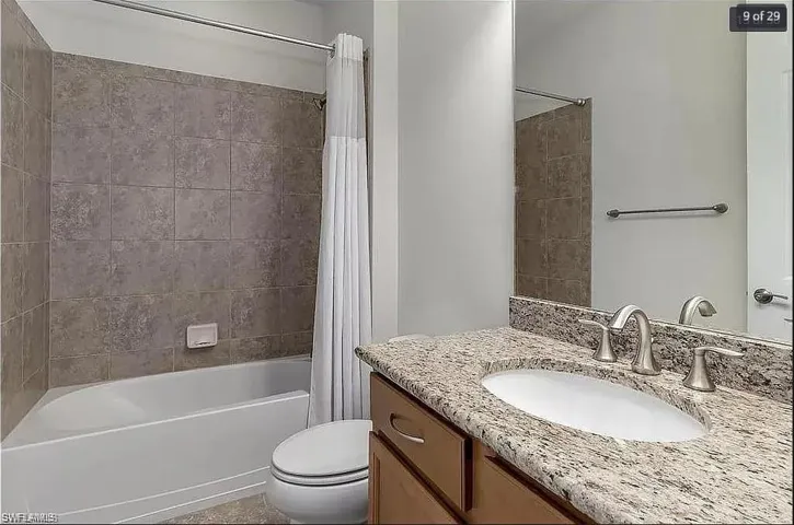 Stylish bathroom with modern fixtures, a granite vanity, and a tub/shower combination.
