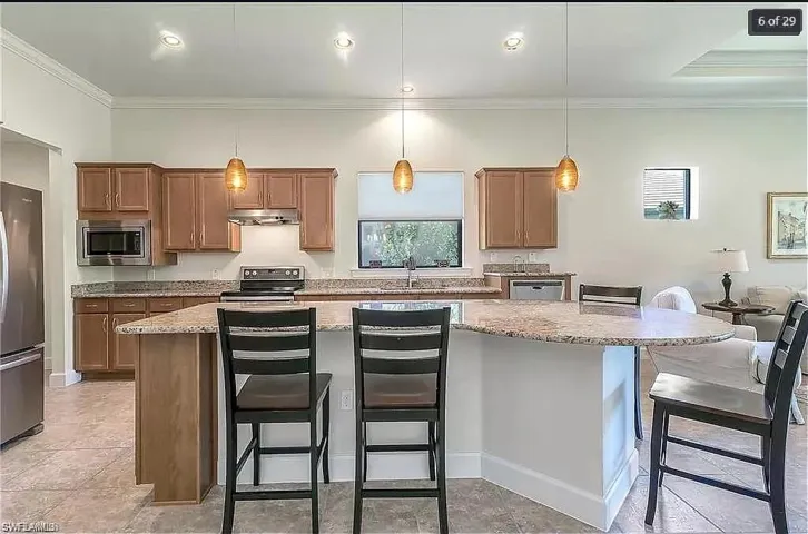 Well-appointed kitchen with stainless steel appliances and bar seating for casual dining.