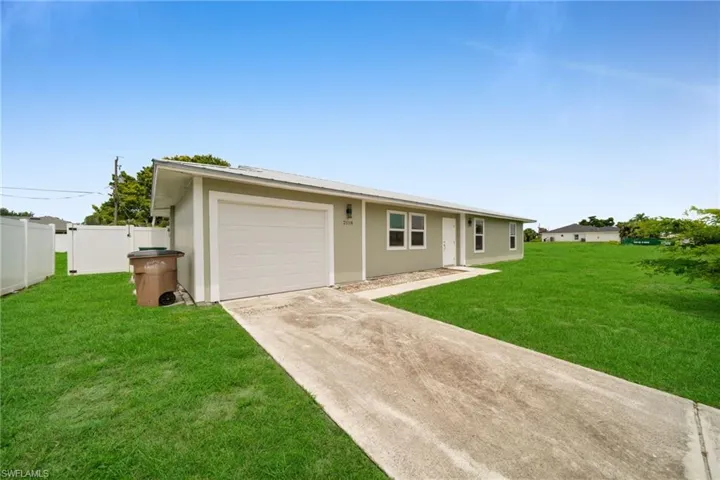Ranch-style home featuring concrete driveway, stucco siding, and an attached garage